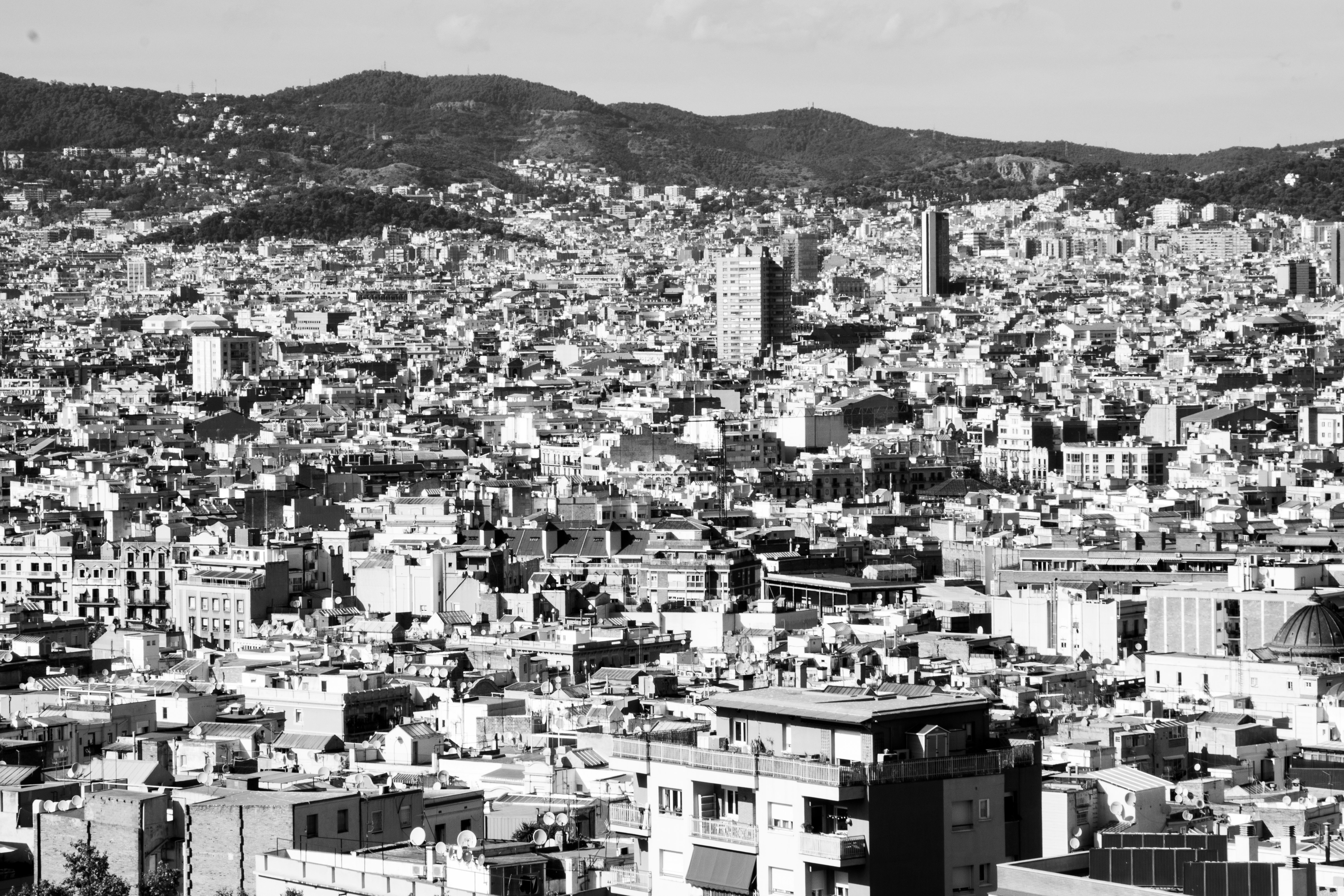 grayscale photo of city buildings near mountain